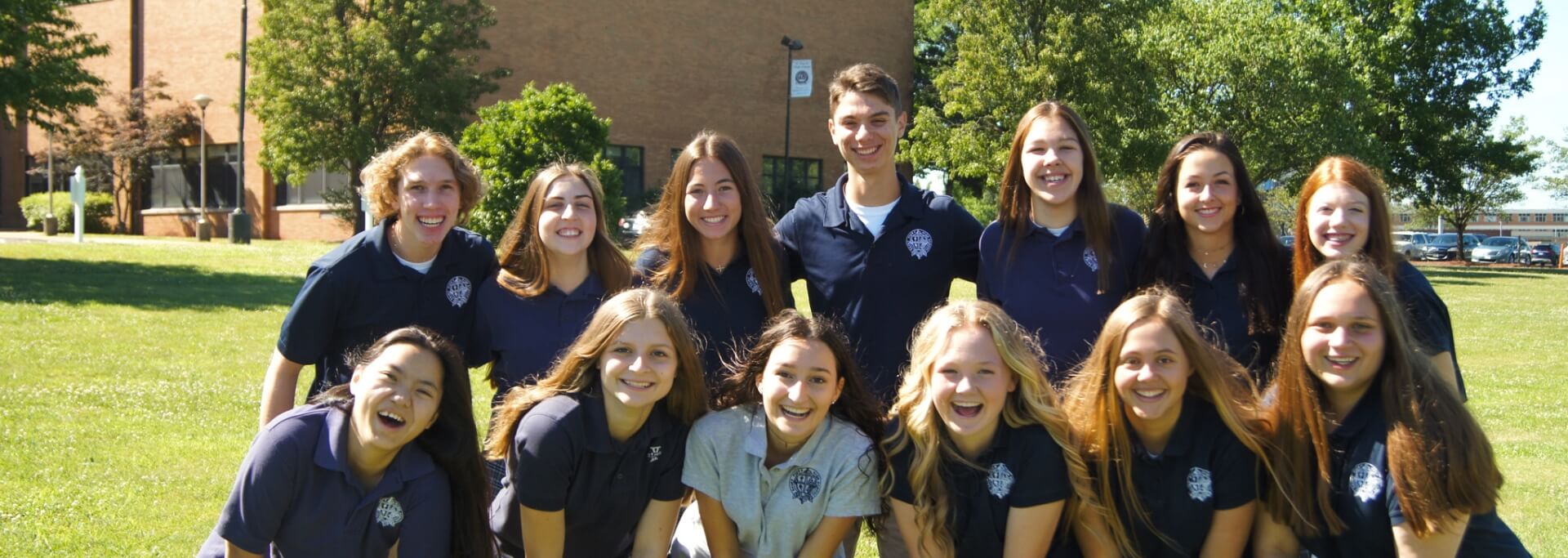Group of smiling students in St. Pius X school shirts