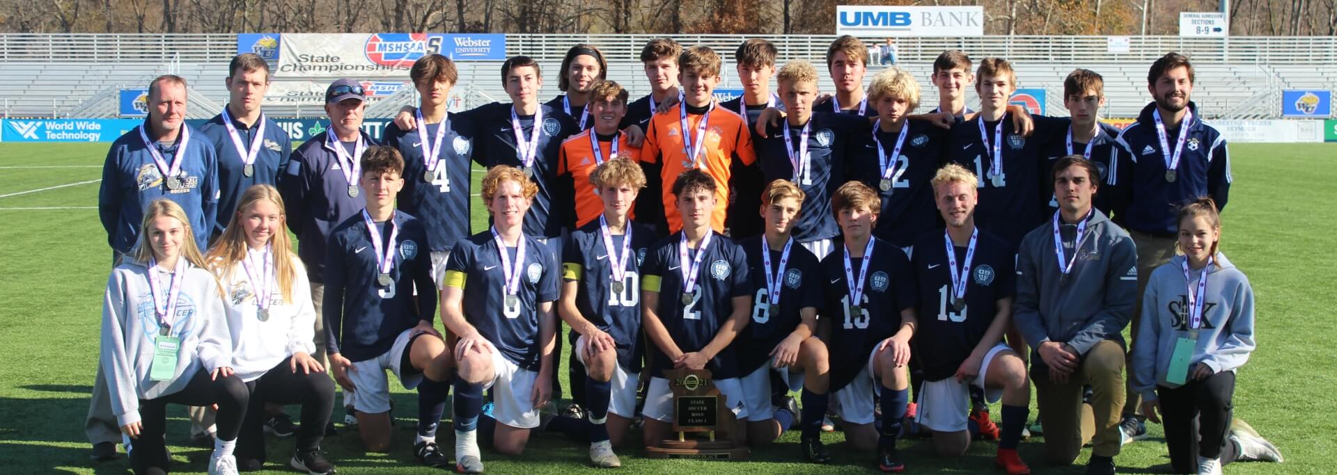 St. Pius X High School athletes posing in uniform with the trophies and medals they have earned