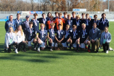 St. Pius X High School athletes posing in uniform with the trophies and medals they have earned